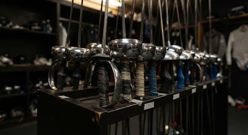 Organized fencing blades and gear in an academy armory